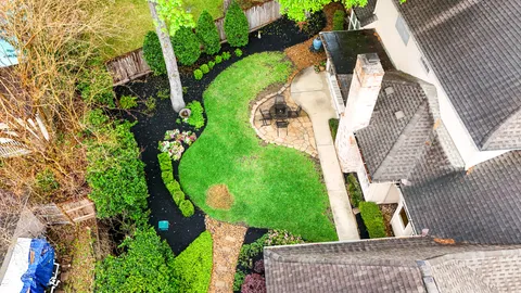 an aerial view of a house with a yard and trees