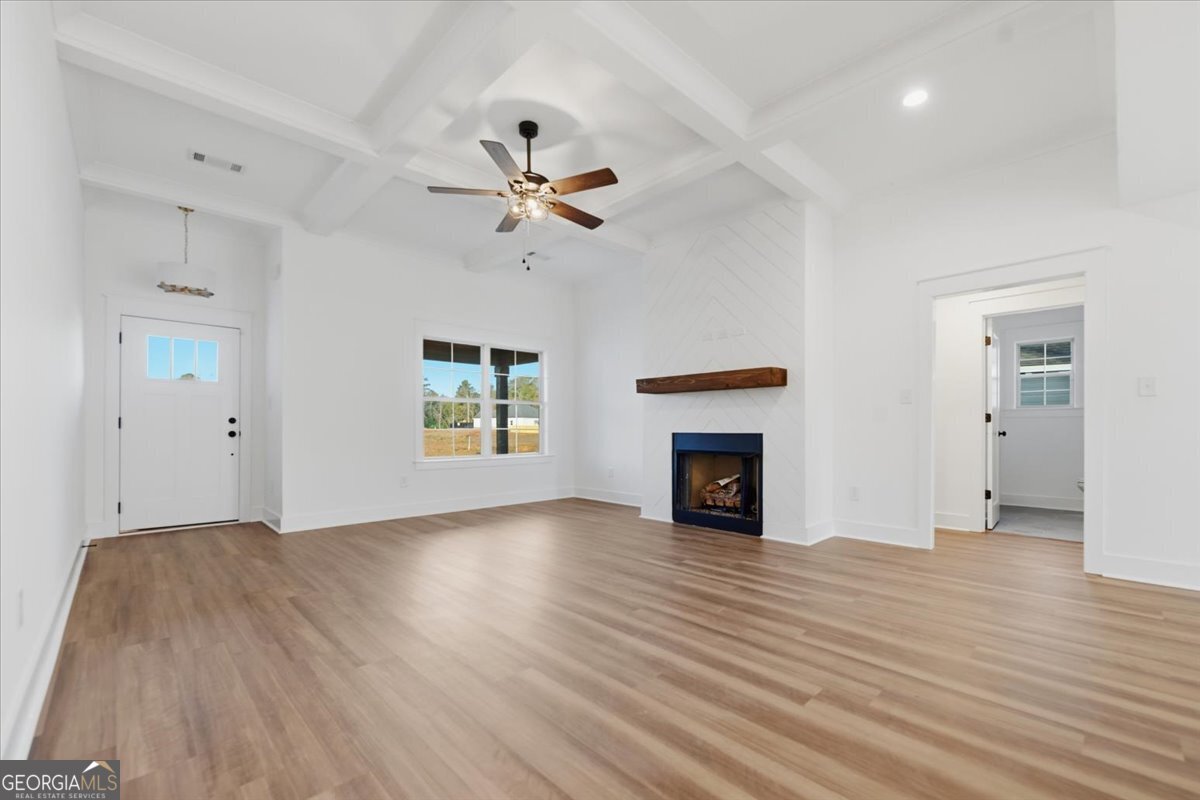 514 New Hope Drive Perry, GA 31069 - Photo 14 of 37 an empty room with wooden floor fireplace and windows
