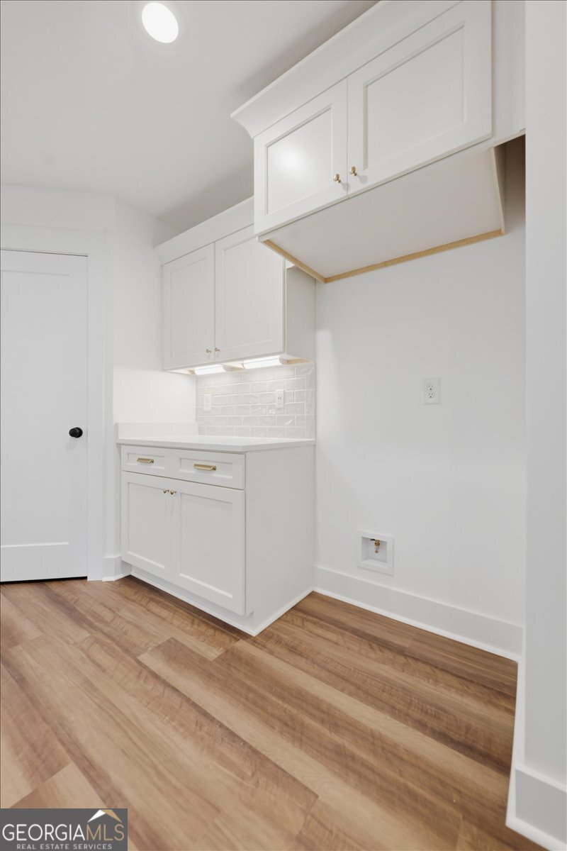 514 New Hope Drive Perry, GA 31069 - Photo 22 of 37 a view of a kitchen with white cabinets and wooden floor