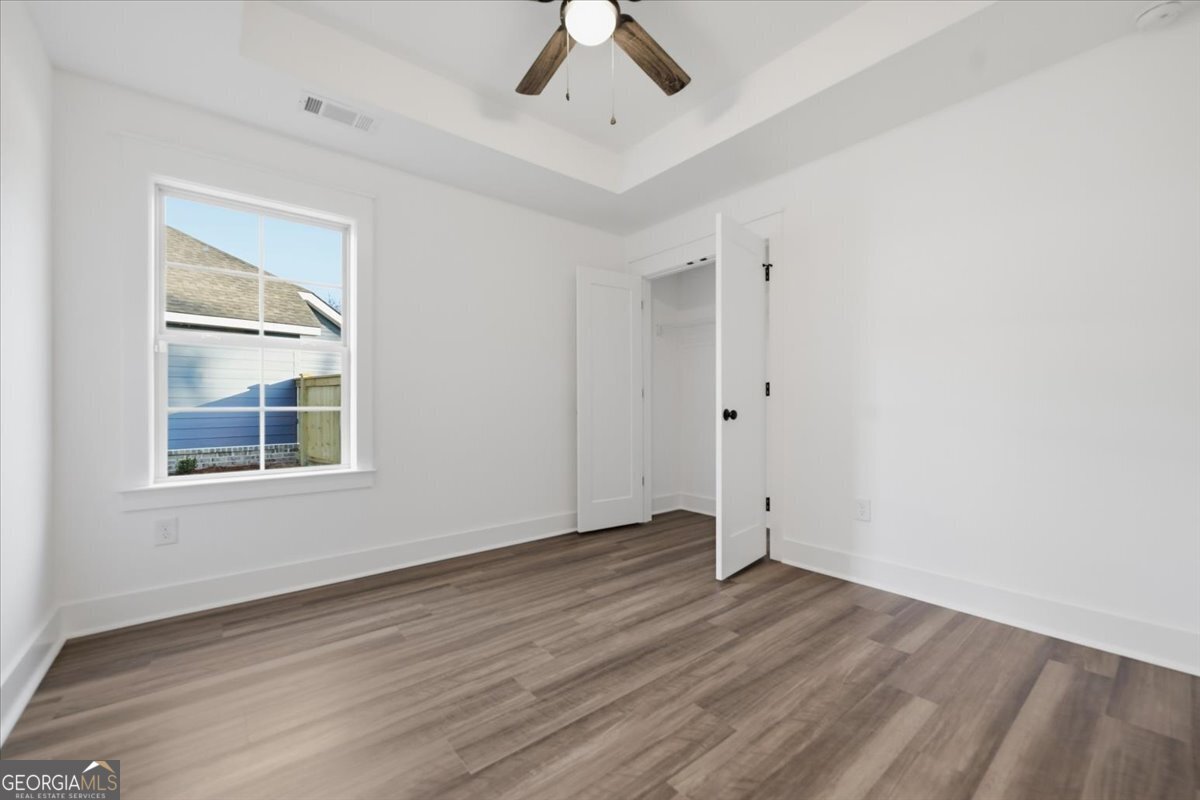 514 New Hope Drive Perry, GA 31069 - Photo 26 of 37 an empty room with wooden floor chandelier fan and windows