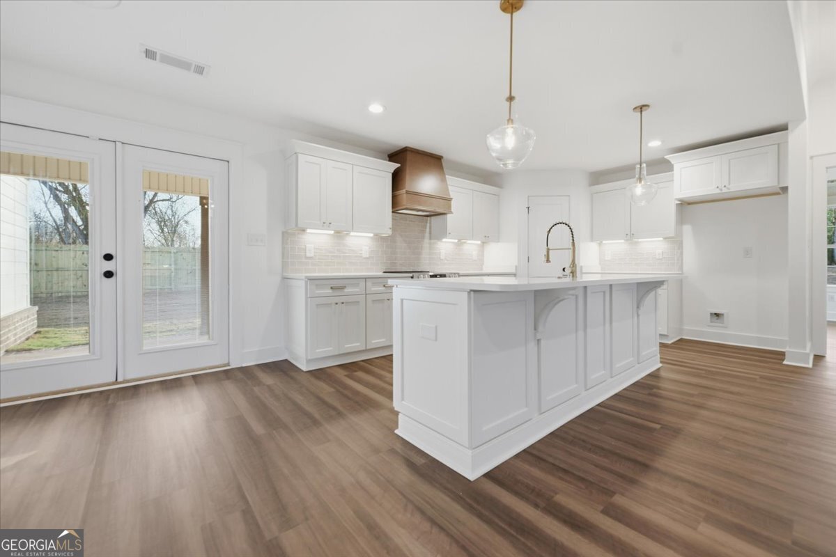 514 New Hope Drive Perry, GA 31069 - Photo 6 of 37 a kitchen with stainless steel appliances granite countertop a refrigerator a sink dishwasher a stove and white countertops with wooden floor