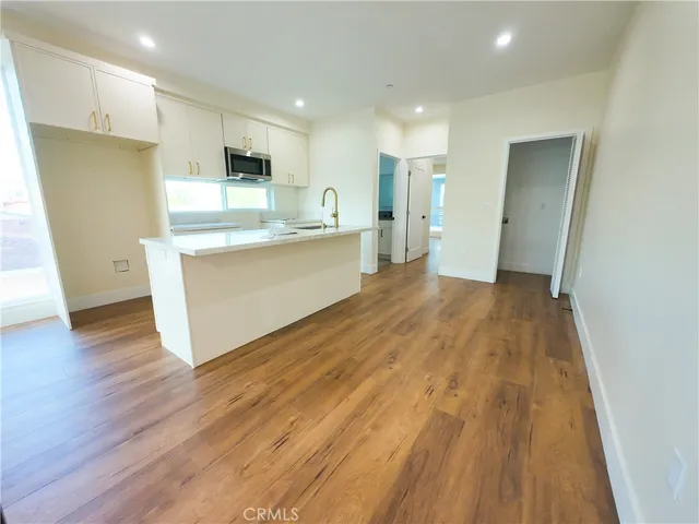 a view of kitchen with wooden floor and electronic appliances