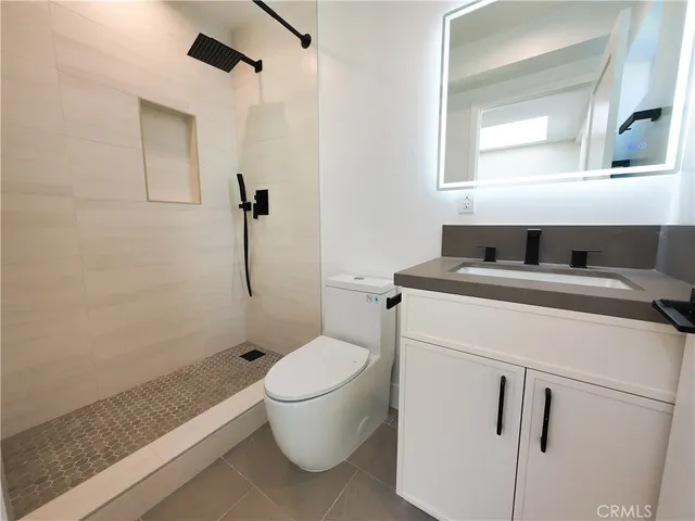 a bathroom with a granite countertop sink toilet and shower