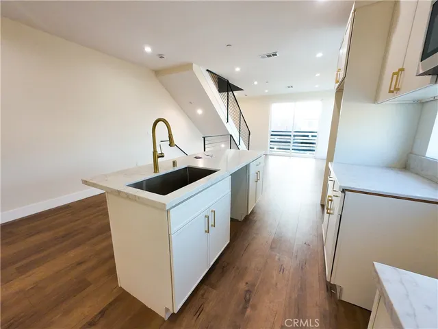 a kitchen with stainless steel appliances granite countertop a sink and a stove top oven