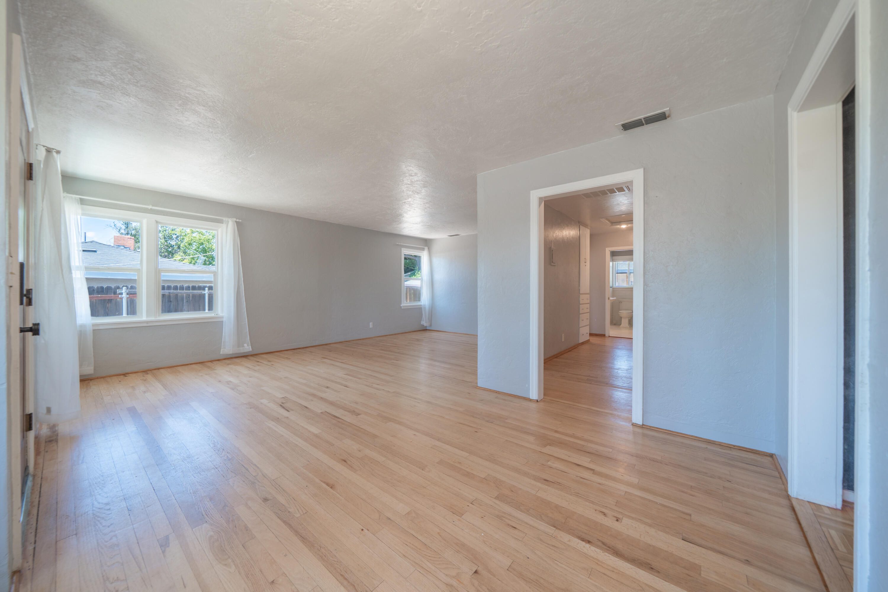 1550 Barbara Road Redding, CA 96003 - Photo 10 of 50 an empty room with wooden floor and windows