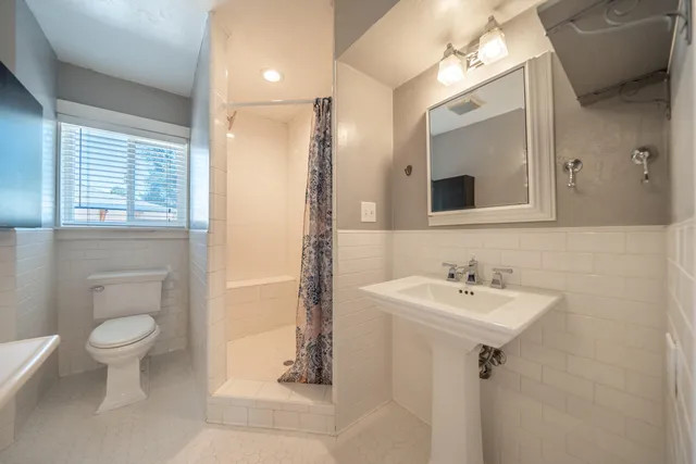 a view of a city with lots of residential buildings ocean and mountain view in back