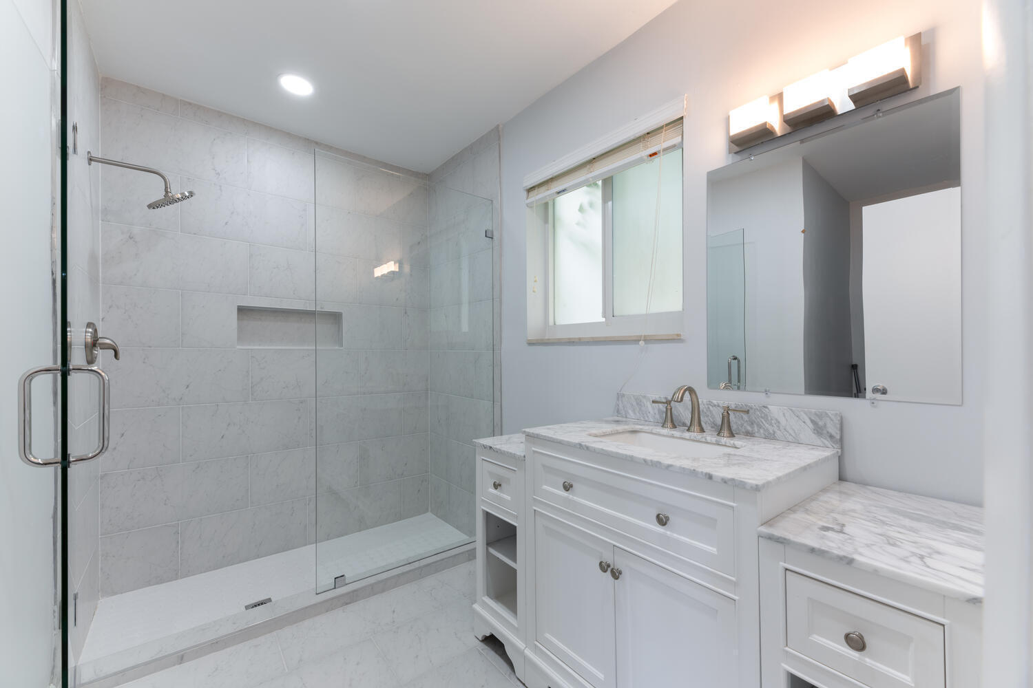 4695 Brandywine Drive Boca Raton, FL 33487 - Photo 18 of 28 a bathroom with a granite countertop sink a mirror and a shower