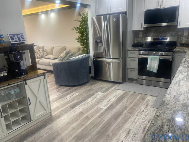 a kitchen with stainless steel appliances wooden cabinets a refrigerator and a stove