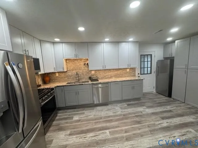 a large kitchen with a refrigerator and a sink