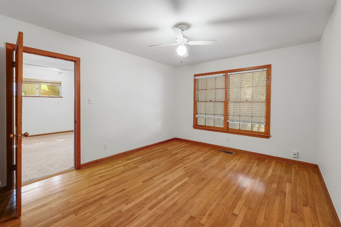 1205 Palo Duro Road Austin, TX 78757 - Photo 14 of 31 a view of an empty room with wooden floor and a window