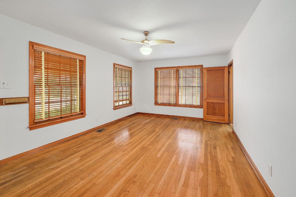 1205 Palo Duro Road Austin, TX 78757 - Photo 4 of 31 an empty room with wooden floor and windows