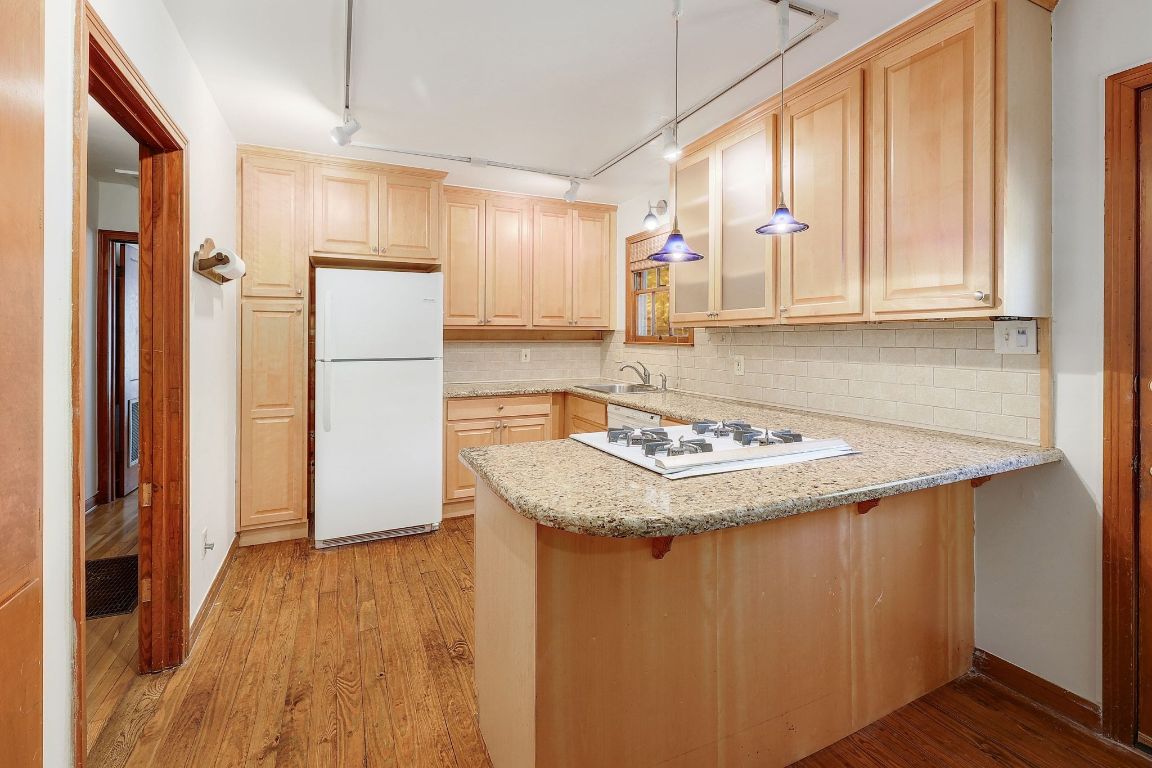 1205 Palo Duro Road Austin, TX 78757 - Photo 7 of 31 a kitchen with a sink a refrigerator and a stove top oven