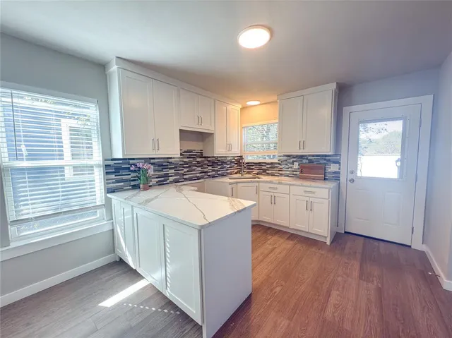 a view of a kitchen counter top a sink and dishwasher with wooden floor