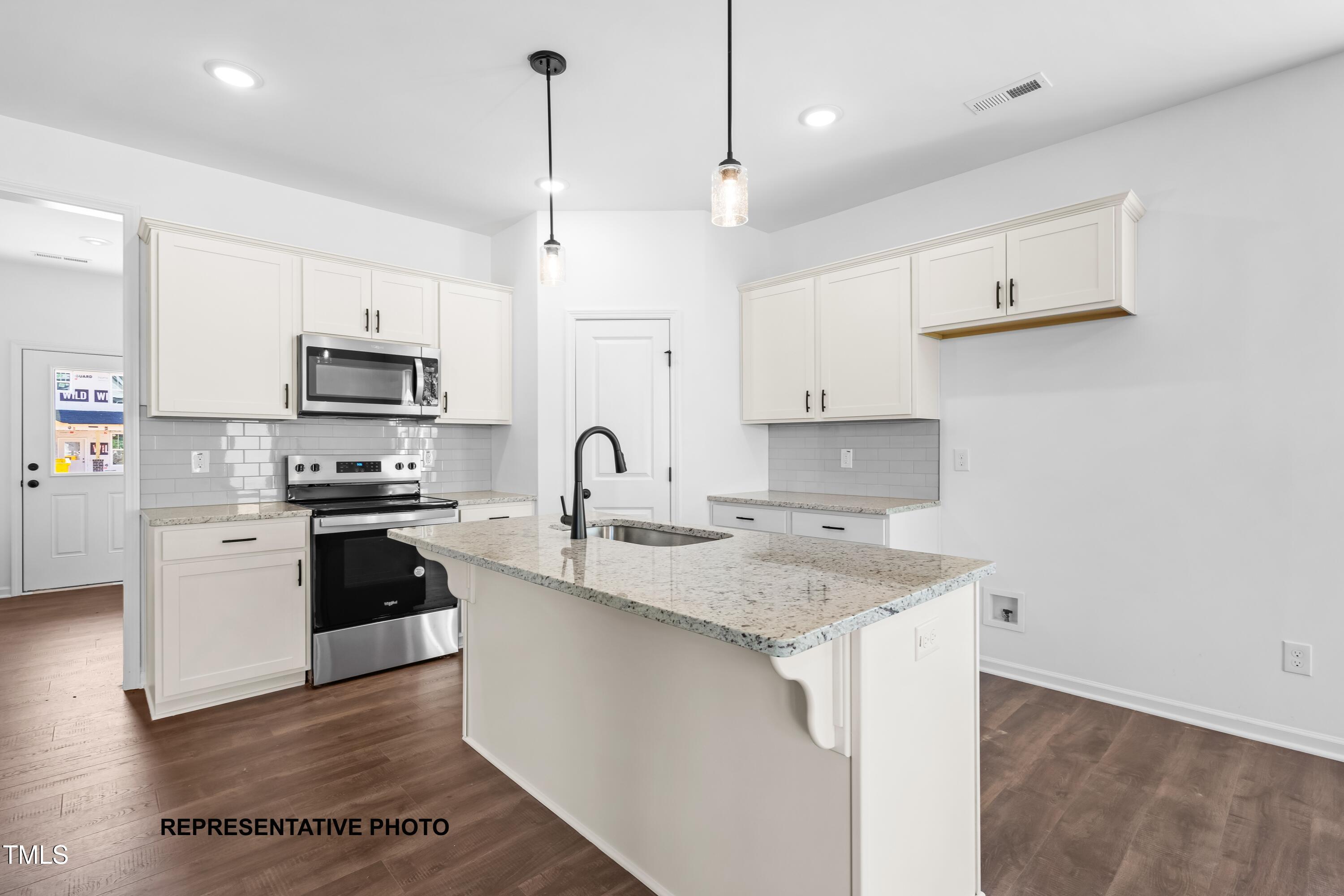 280 Bluejay Street Clayton, NC 27520 - Photo 3 of 14 a kitchen with granite countertop a sink a counter space stainless steel appliances and cabinets