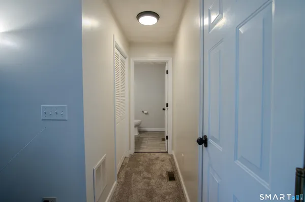 a view of a hallway with a livingroom and a bathroom with sink