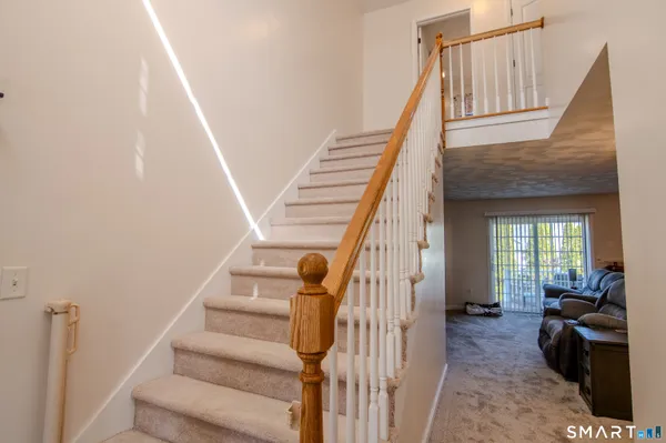 a view of entryway and hall with wooden floor