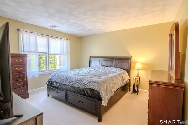 a spacious bedroom with a bed and a window