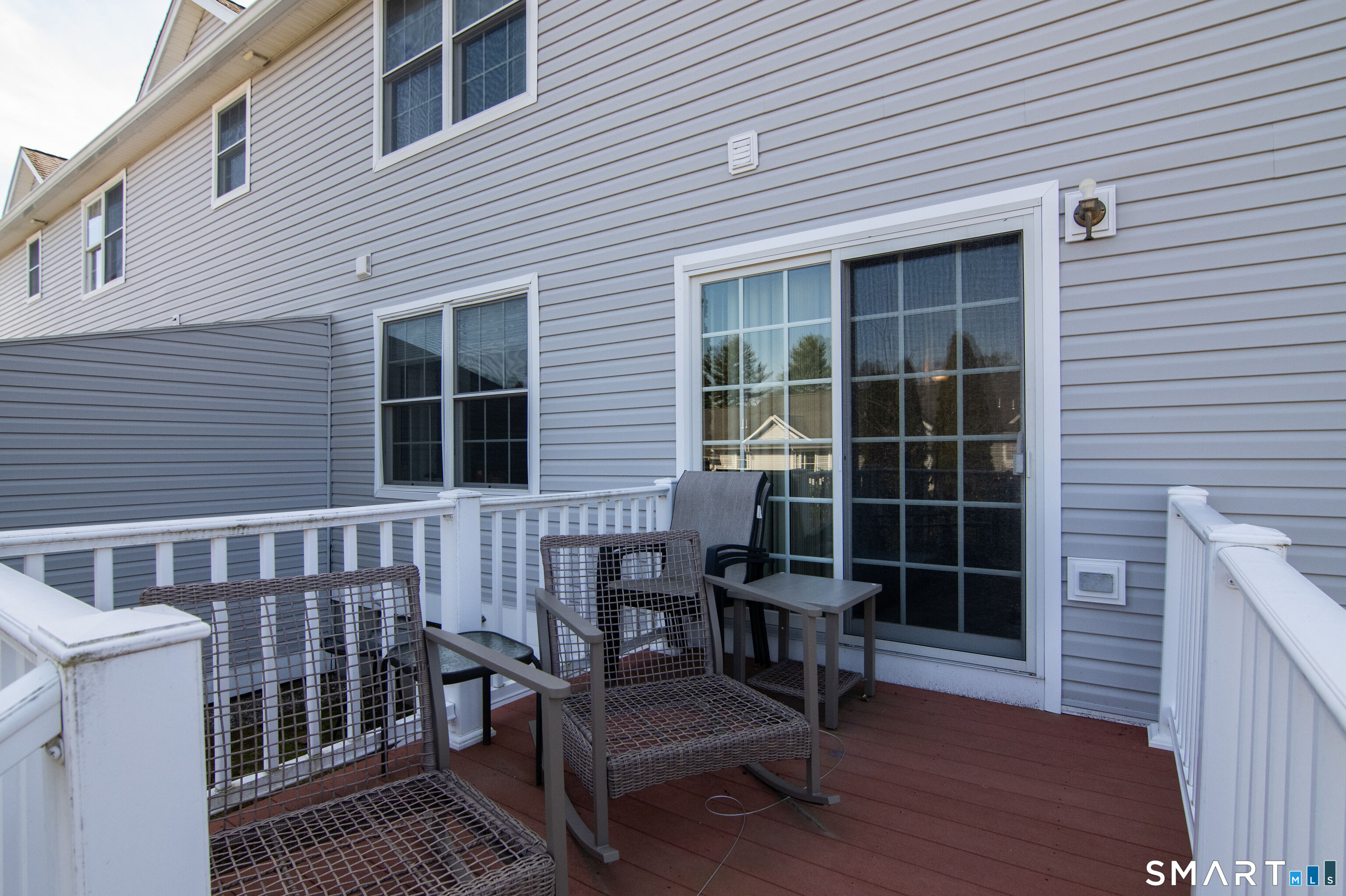 297 Sabin Street, Unit 1 Putnam, CT 06260 - Photo 3 of 20 a view of a deck with table and chairs and wooden floor