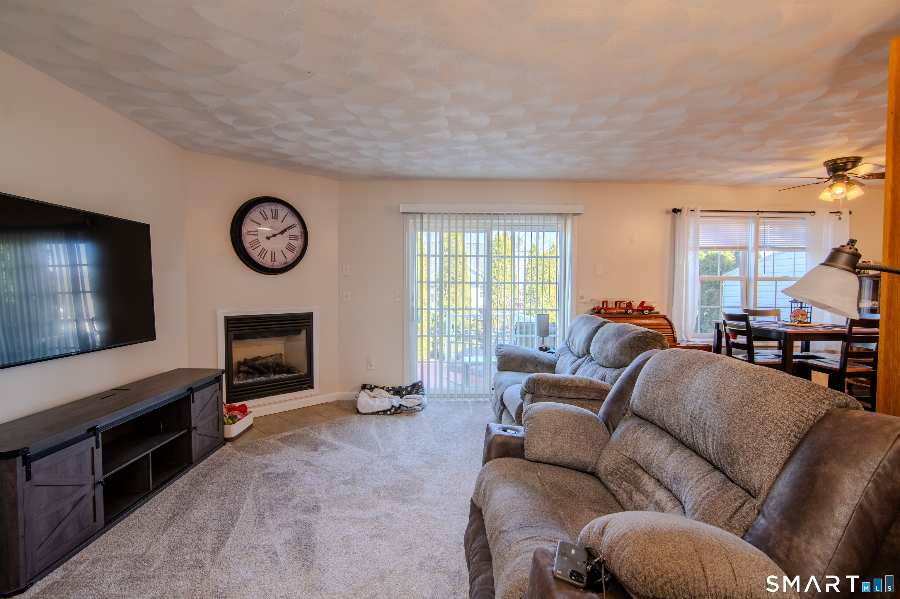 297 Sabin Street, Unit 1 Putnam, CT 06260 - Photo 5 of 20 a living room with furniture a flat screen tv and a fireplace