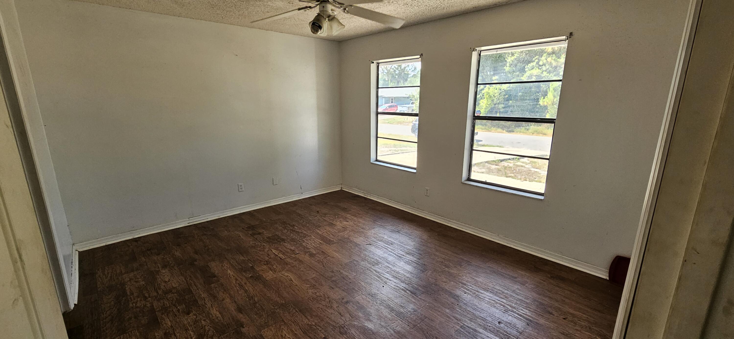 340 San Marino Road Southwest Palm Bay, FL 32908 - Photo 4 of 16 a view of an empty room with a window and wooden floor