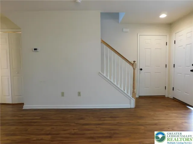 a view of an empty room with wooden floor and entryway