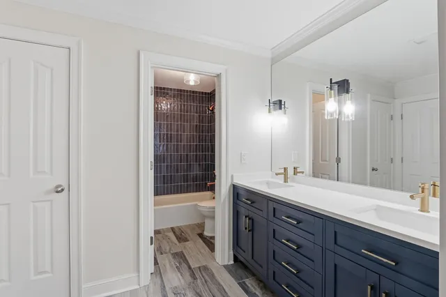 a bathroom with a double vanity sink and mirror with shower