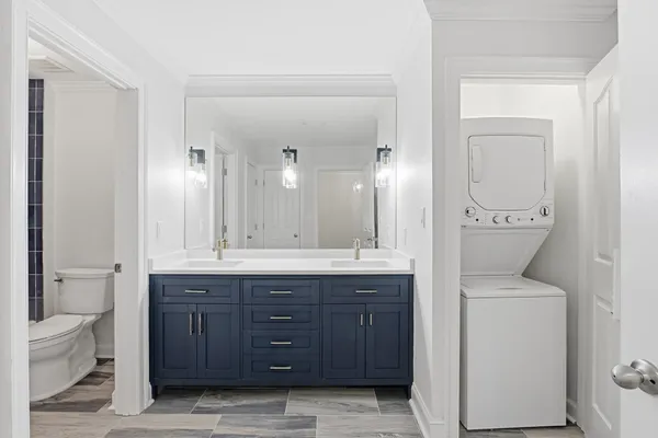 a bathroom with a granite countertop sink a toilet and a mirror