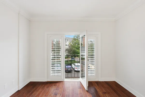 a view of a room with wooden floor and a window