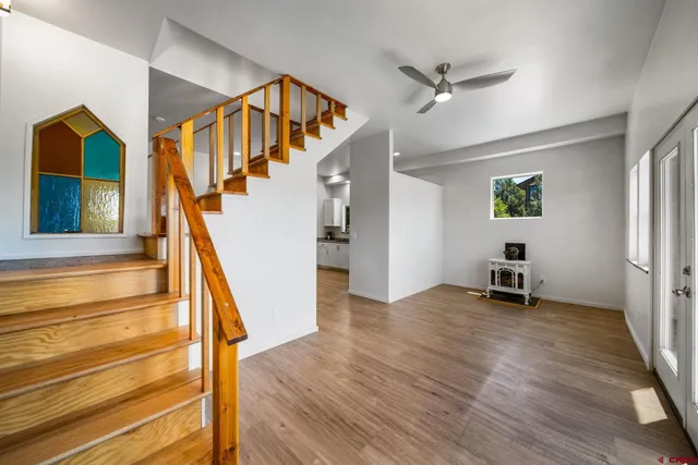 a view of a hallway with wooden floor and a living room