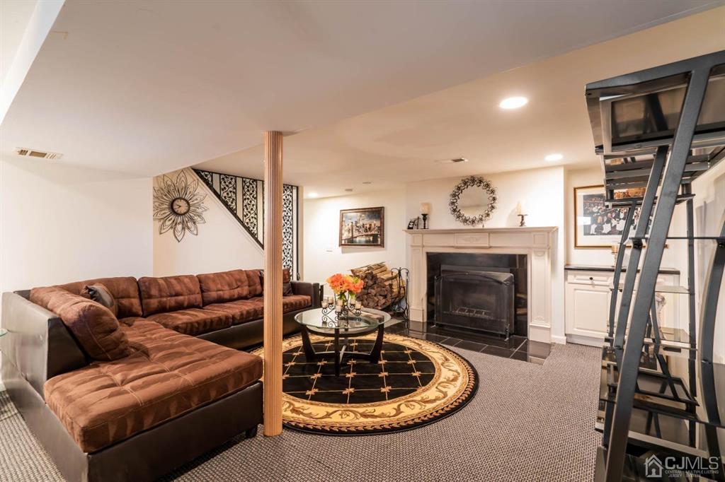 40 Kimberly Road Colonia, NJ 07067 - Photo 21 of 30 a living room with furniture a fireplace and a flat screen tv