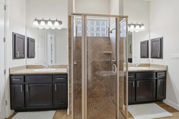 a bathroom with a granite countertop sink a shower and a mirror