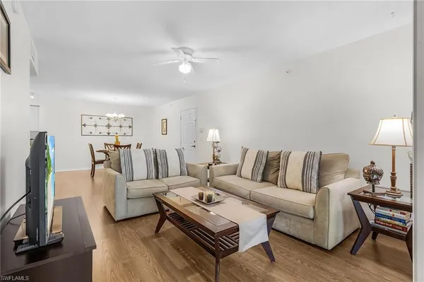 a living room with furniture a lamp and a flat screen tv