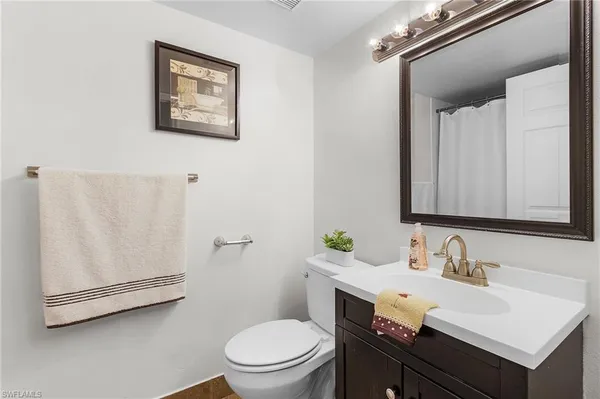 a bathroom with a sink vanity mirror and toilet