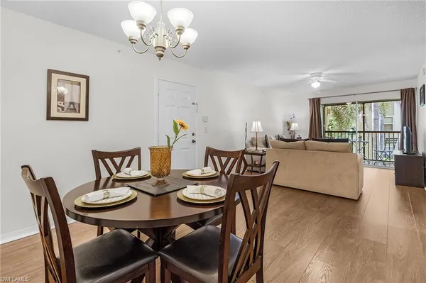 a view of a dining room with furniture a chandelier and wooden floor
