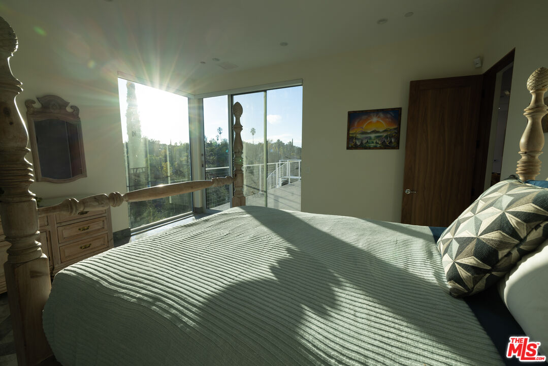 Undisclosed Address Woodland Hills, CA 91367 - Photo 30 of 75 a bedroom with a bed and a flat tv screen next to a window