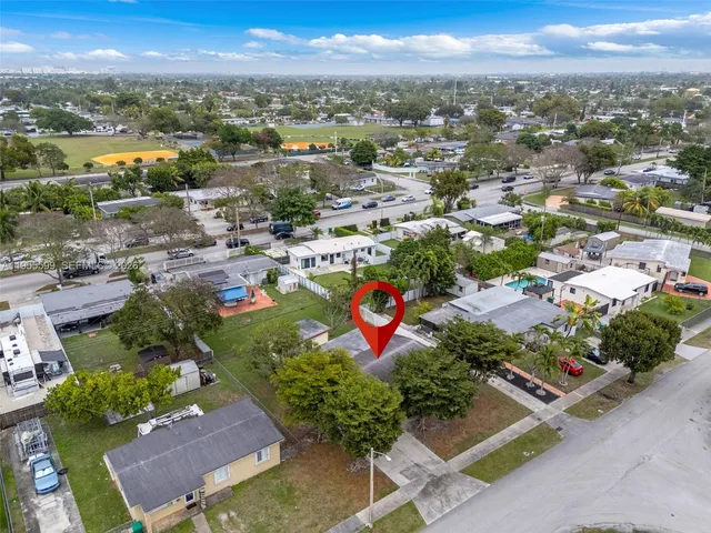 an aerial view of residential houses with outdoor space and trees