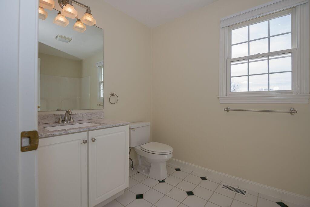 5 Boundary Stone Road Sutton, MA 01590 - Photo 25 of 42 a bathroom with a granite countertop toilet a sink a mirror and a window