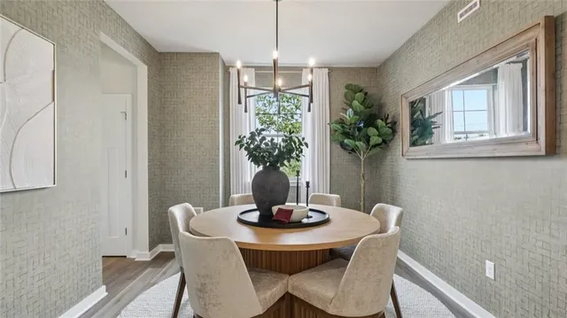 a kitchen with stainless steel appliances granite countertop a stove top oven a refrigerator a sink and chairs