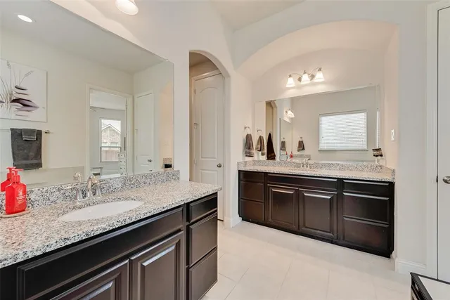 a bedroom with a bed and a flat tv screen on dresser