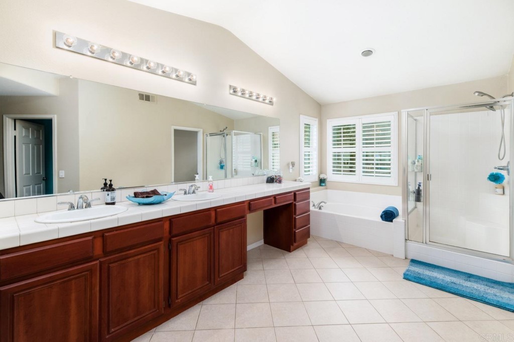 34063 Abbey Road Temecula, CA 92592 - Photo 21 of 33 a spacious bathroom with a double vanity sink a mirror and a bathtub