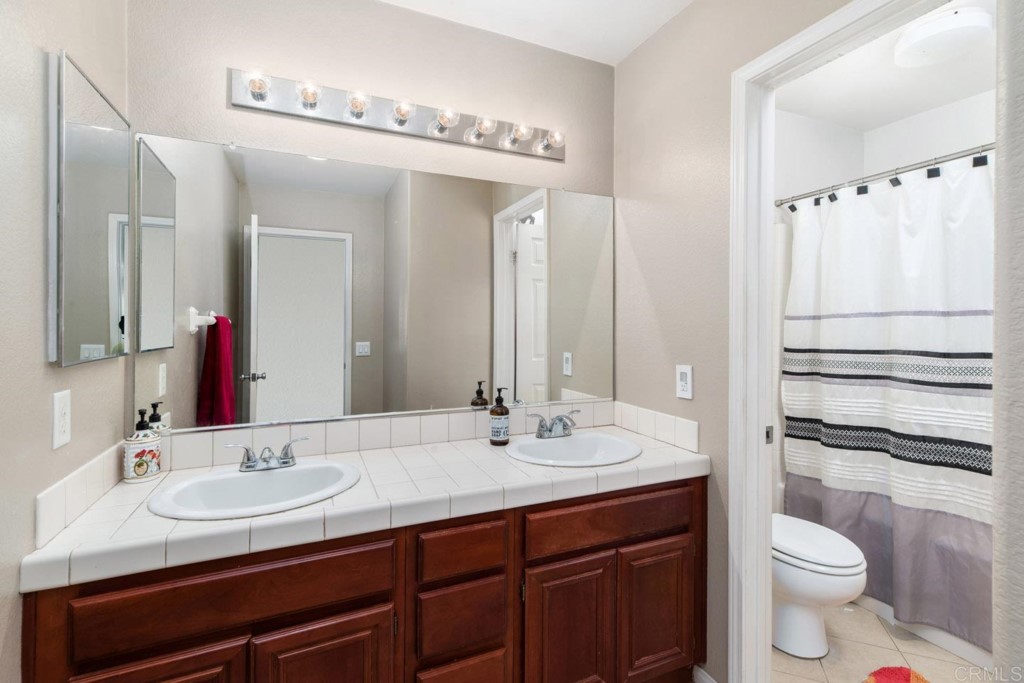 34063 Abbey Road Temecula, CA 92592 - Photo 25 of 33 a bathroom with a granite countertop sink toilet and shower
