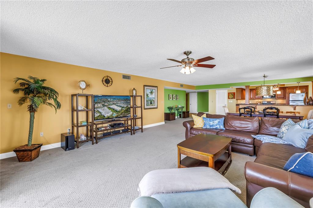 6600 Sunset Way, Unit 118 St. Pete Beach, FL 33706 - Photo 12 of 64 a living room with furniture and a flat screen tv