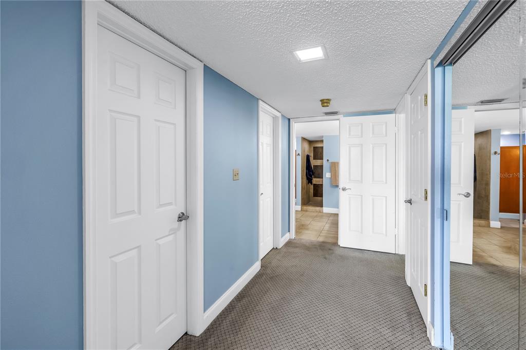 6600 Sunset Way, Unit 118 St. Pete Beach, FL 33706 - Photo 26 of 64 a view of a hallway with wooden shelves