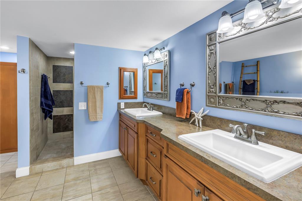 6600 Sunset Way, Unit 118 St. Pete Beach, FL 33706 - Photo 27 of 64 a spacious bathroom with a double vanity sink and a mirror
