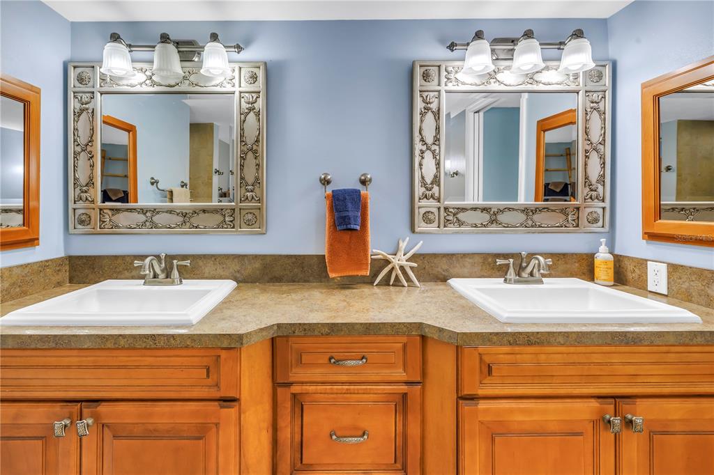 6600 Sunset Way, Unit 118 St. Pete Beach, FL 33706 - Photo 28 of 64 a bathroom with a granite countertop sink and a mirror