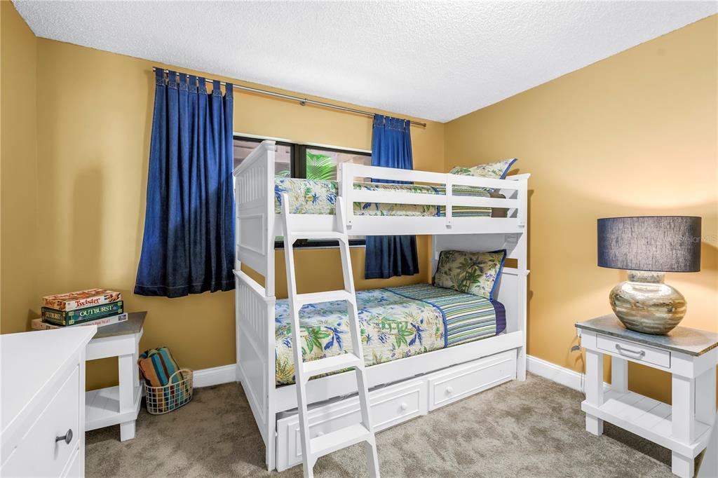 6600 Sunset Way, Unit 118 St. Pete Beach, FL 33706 - Photo 35 of 64 a bedroom with furniture and a bed