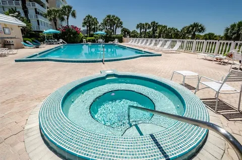 a large kitchen with granite countertop a sink a stove counter space and cabinets