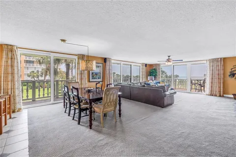 a kitchen with stainless steel appliances granite countertop a stove top oven a sink dishwasher a dining table and chairs with wooden floor