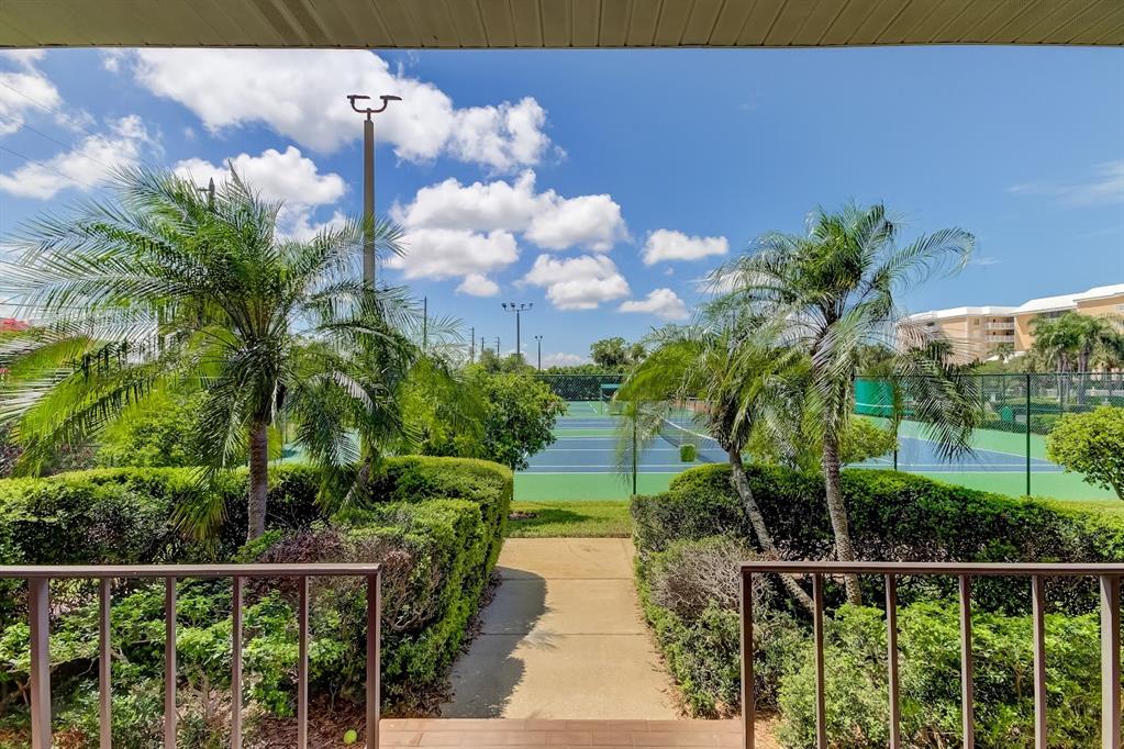 6600 Sunset Way, Unit 118 St. Pete Beach, FL 33706 - Photo 59 of 64 a view of a pathway of a house next to a yard