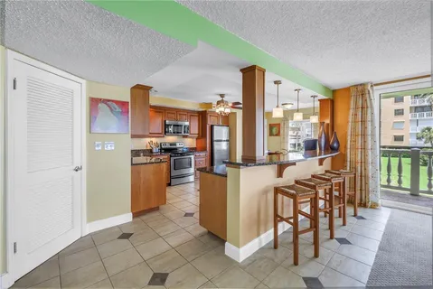 a kitchen with stainless steel appliances granite countertop stove top oven dining table and chairs
